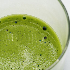 Išplakta premium matcha stiklinėje prieš pilant augalinį pieną